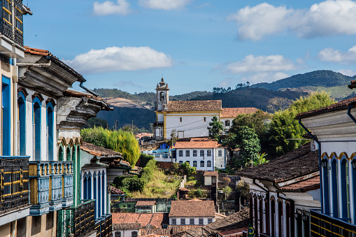 Old city in Minas Gerais, Brazil. Houses with their tile roofs and a church in the back. A blue sky day