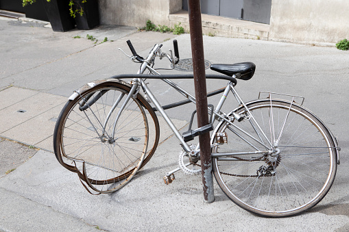 Classic style grey vintage Dutch bicycle in front of brick wall.