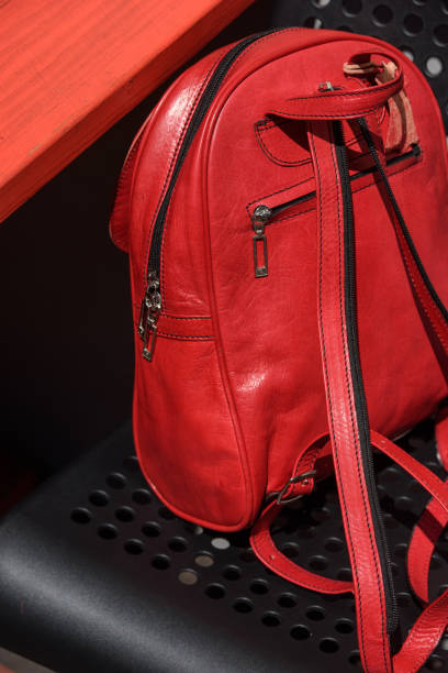 istock Red leather casual unisex backpack on a black chair 1414001395
