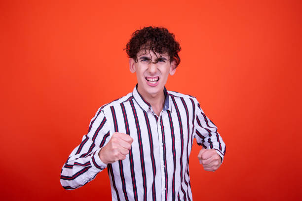 istock Emotions of a young attractive guy. Orange background. 1414002747
