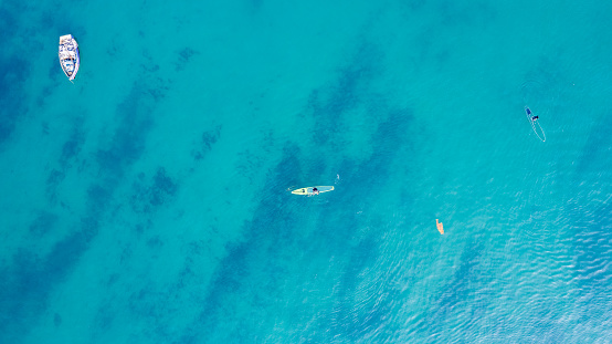 People practicing paddleboarding on the crystal clear turquoise shores