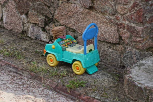 lost green little toy car behind iron fence at courtyard of new residential complex in Berlin