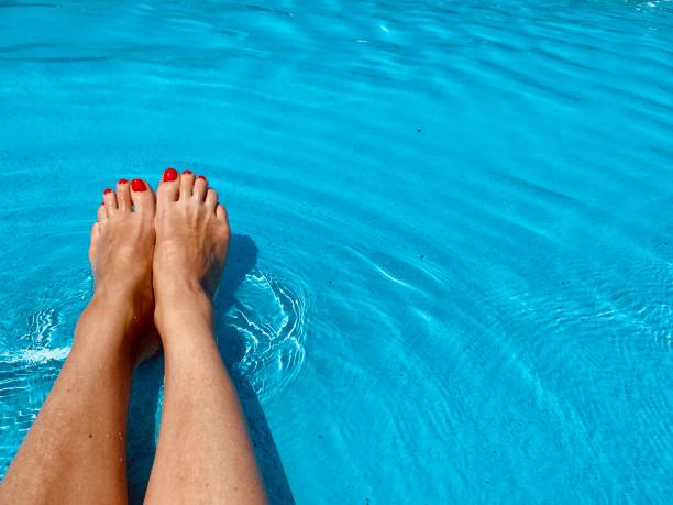 Female feet in the pool. Copy space