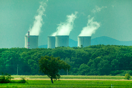View of a large industrial chimney in green nature.