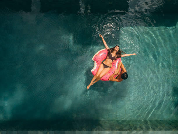 para relaksująca się w basenie wypoczynkowym - poolside swimming pool resort swimming pool hotel zdjęcia i obrazy z banku zdjęć