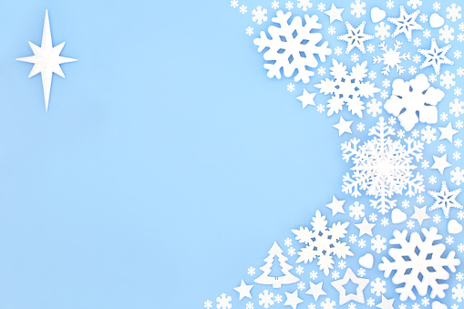 Christmas festive star of Bethlehem and snowflake background border on pastel blue. Fantasy design concept, abstract composition for winter, Xmas and New Year holiday season.