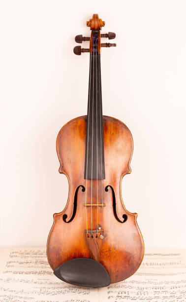 istock Old Classical Violin and bow with music sheets in the background 1414008390