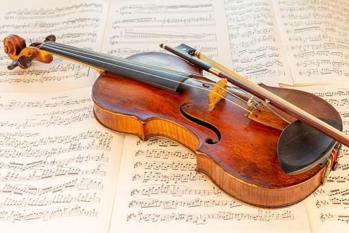 Close up view of an old Classical Violin lying on music score sheets: Brahms-Violin Concert