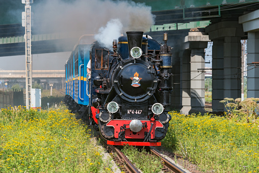 Saint Petersburg, Russia - August 06, 2022: Steam train of Children's railway approaches to the station.