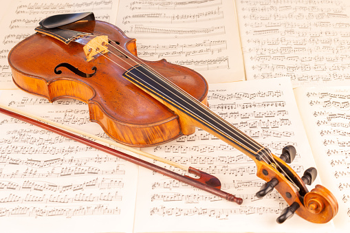 Close up view of an old Baroque Violin lying on music score sheets: Brahms-Violin Concert