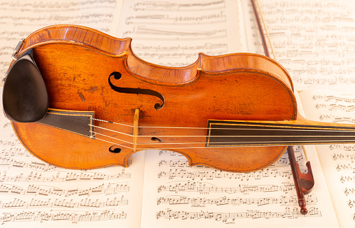 Close up view of an old Baroque Violin lying on music score sheets: Brahms-Violin Concert