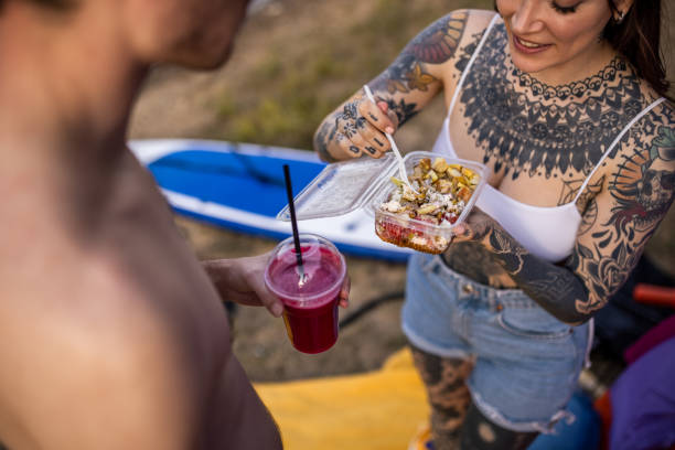 istock Caucasian couple, eating and drinking, while camping near lake 1414012577