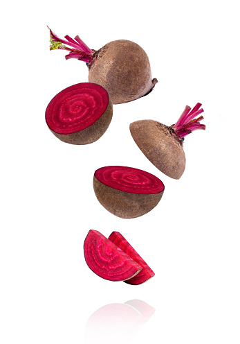 Closeup beetroot (beet root) and half sliced flying in the air isolated on white background.