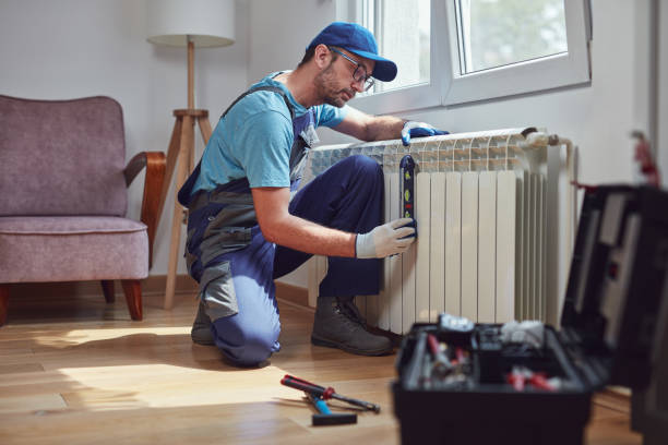 central heating mechanic and handyman fixing home radiator, gas crisis and seasonal issues. - heating engineer imagens e fotografias de stock