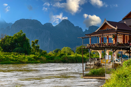 Caves water falls in Vang Vieng Laos with Making river flowing slowly and lush green mountains rising high
