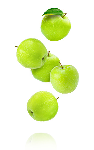 Fresh green apple fruit with water droplets flying in the air isolated on white background.