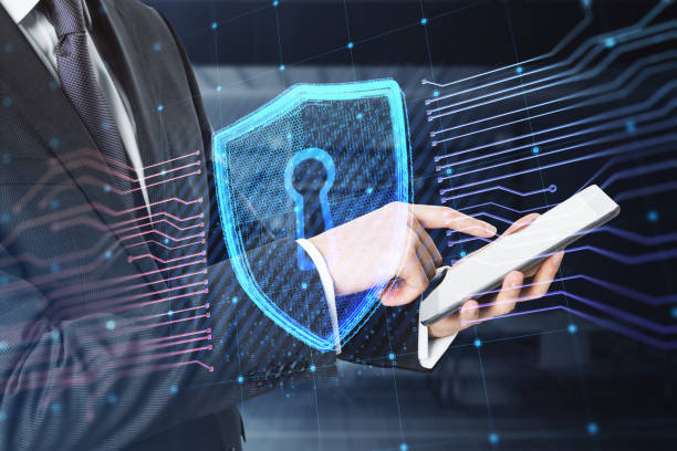 istock Close up of businessman hands using cellphone with creative glowing shield circuit security hologram on blurry office interior background. Safety and web protection concept. Double exposure. 1414019084