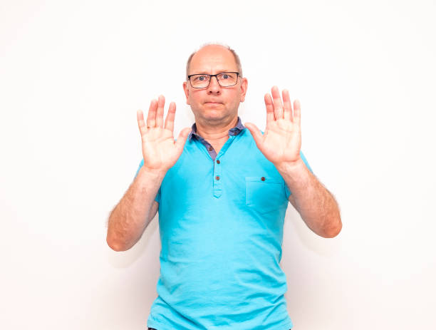 istock A middle-aged Caucasian man raised his hands up, a gesture of refusal. 1414022152