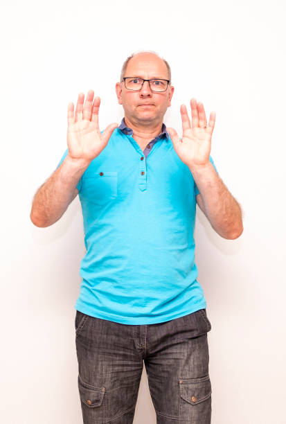 istock A middle-aged Caucasian man raised his hands up, a gesture of refusal. 1414023028