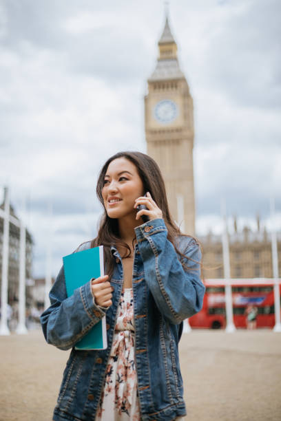 istock Happy female asian student using phone in London 1414025011