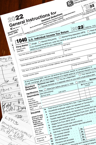 2022 IRS tax forms and home owner written notes lay on a desktop.