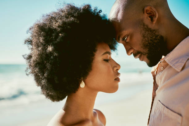 istock Beautiful, sexy and handsome african couple posing outside while looking confident, seductive and alluring at a beach. Loving, affectionate and caring boyfriend and girlfriend on holiday by the sea 1414026419