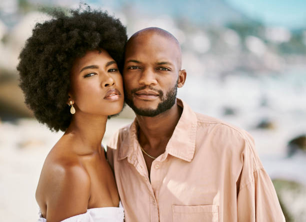 istock Beautiful, attractive african couple posing outside while looking confident at a beach on blurred background. Portrait of loving, affectionate and caring boyfriend and girlfriend on holiday 1414026444