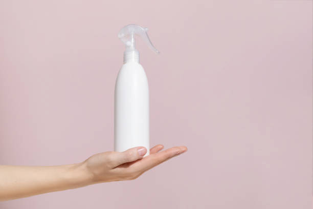 istock Woman hold white blank spray detergent bottle. Mockup 1414026856