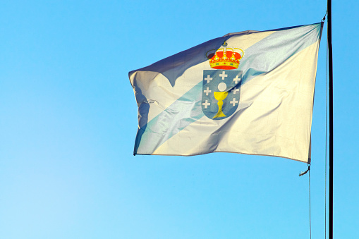 Close-up of Portuguese flag at sunset fluttering in the wind with blue sky in the background near Elvas. A gracious star-shaped fortress city on the easternmost frontier of Portugal.