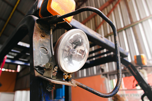 Halogen car spotlights on the forklift in the auto repair garage.