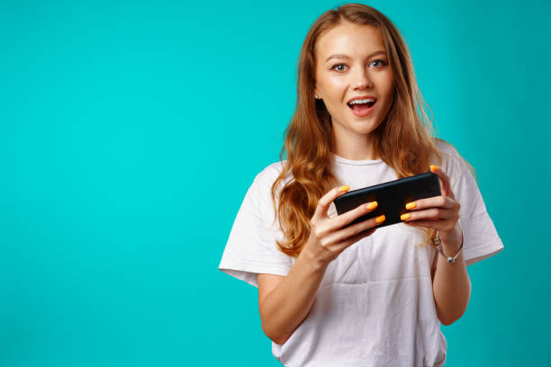 istock Young smiling woman standing and using her smartphone 1414029517