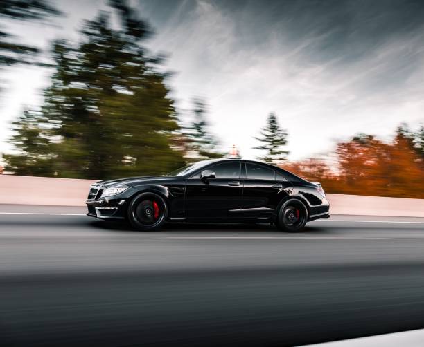 Seattle, WA, USAJuly 15, 2022Black Mercedes Benz CLS 63 AMG driving on the freeway with trees in the background