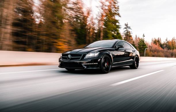 Seattle, WA, USA\nJuly 15, 2022\nBlack Mercedes Benz CLS 63 AMG driving on the freeway with trees in the background