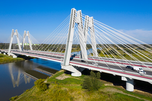 Aerial view of the suspension bridge with traffic over the river in the summer, landscape in Germany.