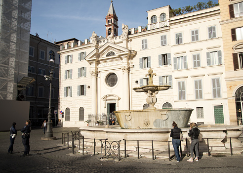 Rome - 10/28/2021: a view of Piazza Farnese (Farnese Square), near Campo de Fiori, in the historic heart of Rome. On the right a fountain built in 1626 by the architect Girolamo Rainaldi,  and behind the church of Santa Brigida (St Bridget of Sweden), built in 1705 in the place where the Saint lived until his death, in 1373. Rome, Italy.