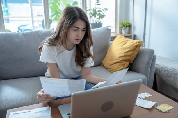 istock Young Asian woman stressed when she saw the expenses on her bill, Financial problems, Indebtedness, Lose a job. 1414035405