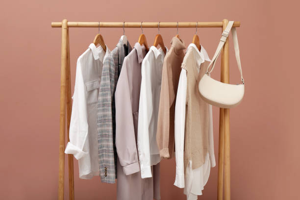 istock Rack with different stylish clothes and bag on pale pink background 1414036043