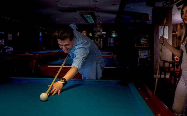 istock Young man playing billiard game ( pool game ) at indoor club 1414036190