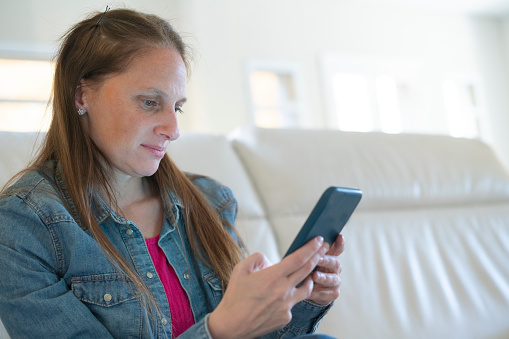 Portrait of a young woman concentrated onwatching  her smartphone