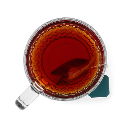 Tea bag in glass cup of hot water isolated on white, top view