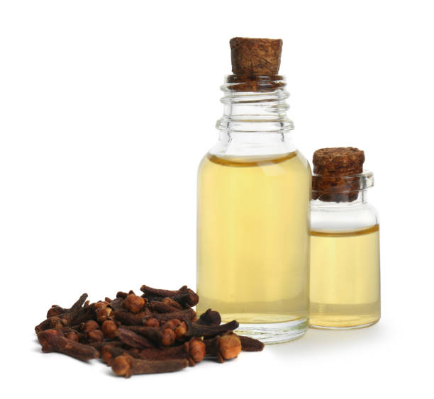 istock Essential oil and dried cloves on white background 1414039994