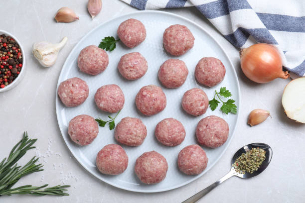 istock Many fresh raw meatballs on white table, flat lay 1414040446