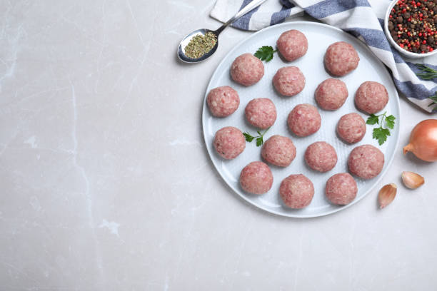 istock Many fresh raw meatballs on light table, flat lay. Space for text 1414040450