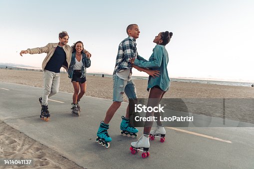 istock Friends roller skating by the beach in California 1414041137