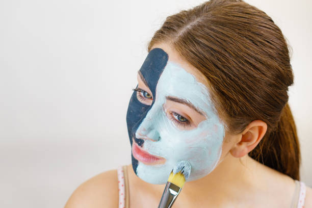 istock Girl black mask on half face apply white mud 1414041393