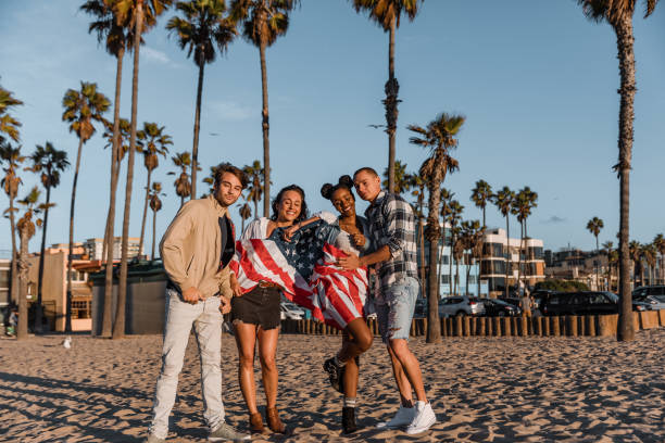 istock Friends posing with an american flag on the beach 1414041670