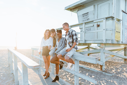 Group of millennials enjoying a sunny day on the beach in Venice Beach, CA.