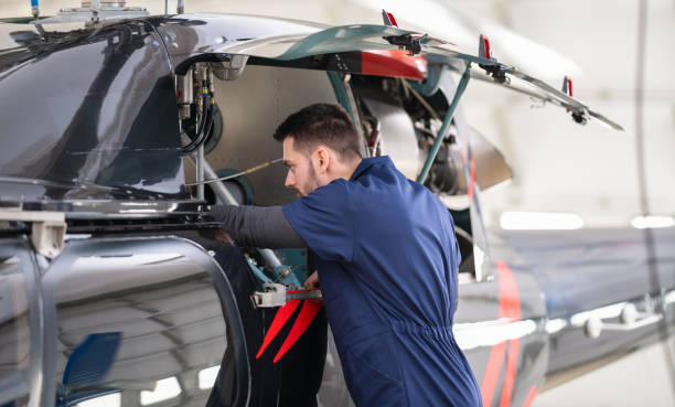 istock Aero Mechanic Fixing And Checking A Helicopter In Hangar 1414042762