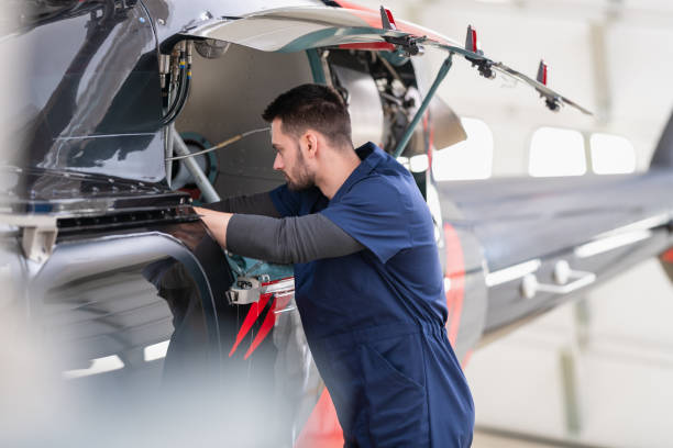 istock Aero Mechanic Fixing And Checking A Helicopter In Hangar 1414042764