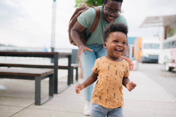 istock Little boy taking his first steps with the help of his father 1414045603